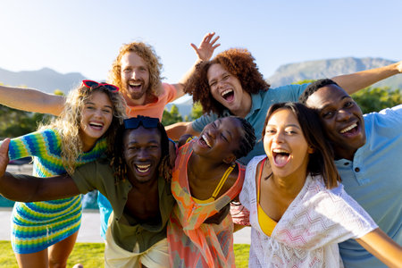 Portrait of happy diverse group of friends having party, smiling in garden. Lifestyle, friendship and party, summer, sunshine, unaltered.の写真素材