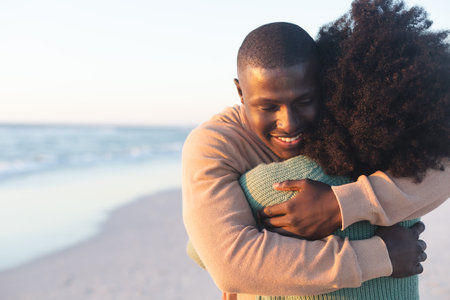 Happy african american couple embracing and smiling on sunny beach, copy space. Summer,...