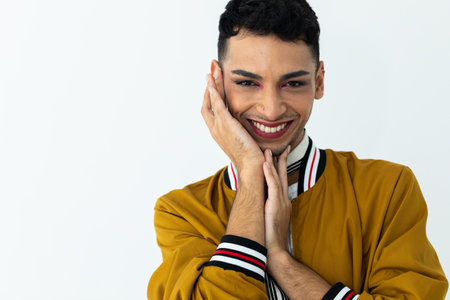 Portrait of happy biracial transgender man wearing make-up, looking at camera on white background....
