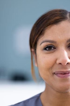 Unaltered portrait of half face of happy asian female doctor smiling in hospital, copy space. Friendly, approachable, job satisfaction, hospital, medical and healthcare services.の写真素材