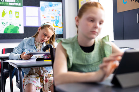 Caucasian schoolgirl in wheelchair with diverse schoolchildren in school classroom. Education, inclusivity, school, learning and disability concept.の写真素材