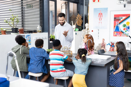 Diverse schoolchildren and male teacher studying plants in elementary school class, with copy space. Education, inclusivity, elementary school and learning concept.の写真素材