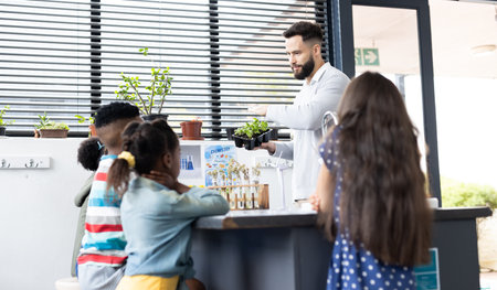 Diverse schoolchildren and male teacher studying plants in elementary school class, with copy space....