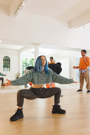 Vertical image of caucasian female hip hop dancer practicing at dance studio with copy space. Dance,...