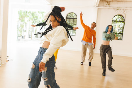 Image of diverse female and male hip hop dancers during training in dance club. Dance, rhythm,...