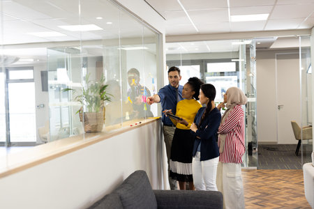Diverse female and male businesspeople in office working and brainstorming. Business, corporation,...