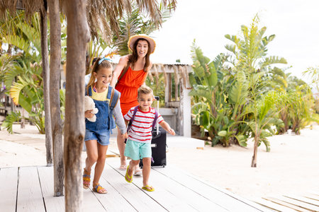 Happy biracial family walking at beach. Spending quality time, lifestyle, family, summertime and vacation concept.の写真素材