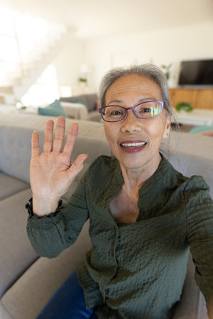 Happy senior asian woman having video call. Spending quality time, lifestyle, domestic life and retirement concept.の写真素材