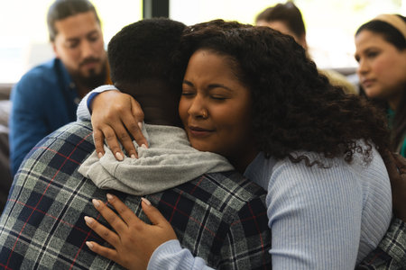 Two african american male and female friends hugging on therapy session. Mental health, therapy, friendship and support, unaltered.の写真素材