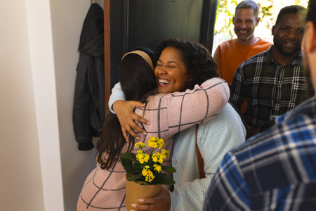 Happy diverse couple receiving guests in sunny house. Lifestyle,relaxation,free time and domestic life, friendship, unaltered.の写真素材