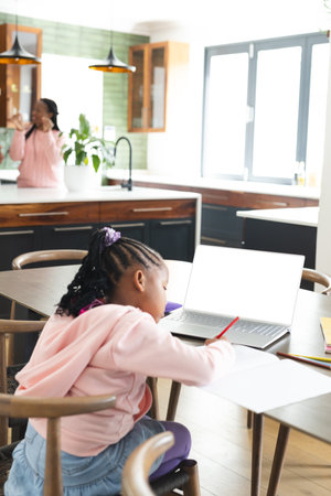 African american girl having online class using laptop with copy space, slow motion. Childhood,...