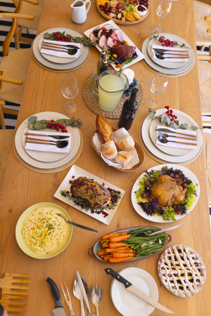 Table with delicious meal prepared for christmas dinner in sunny dining room. Christmas,...