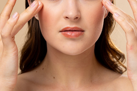Caucasian woman with brown hair wearing natural makeup on beige background. Cosmetics, makeup, female fashion and beauty, unaltered.の写真素材