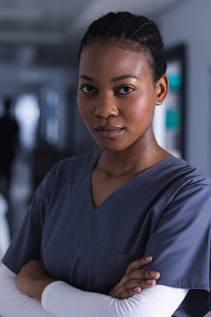 Portrait of african american female doctor in hospital corridor. Medicine, healthcare and medical services, unaltered.の写真素材