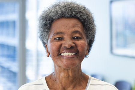 Portrait of happy african american senior woman in hospital. Medicine, healthcare and medical services, unaltered.の写真素材