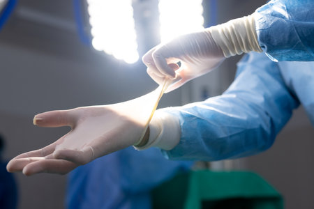 Hands of asian female doctor wearing protective gloves in hospital operating room. Medicine,...