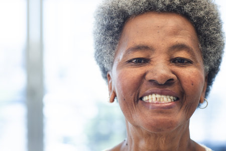 Portrait of happy african american woman in hospital waiting room. Medicine, healthcare and medical...
