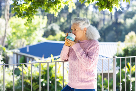 Caucasian senior woman drinking coffee on sunny terrace. Lifestyle, retirement, senior lifestyle,...