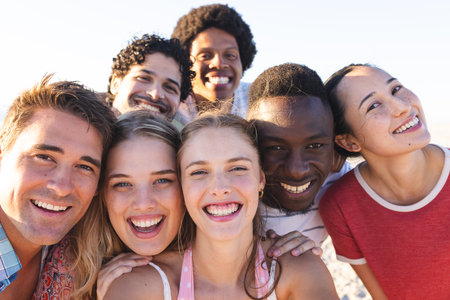 Diverse group of friends enjoying a day at the beach. Radiant smiles capture the essence of a carefree outdoor gathering.の写真素材