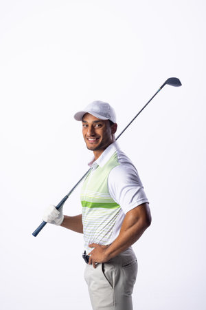 Young biracial man poses with a golf club, with copy space. He exudes confidence in his golf attire, ready for a game.の写真素材