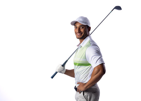 Young biracial man poses confidently with a golf club with copy space. His attire and equipment suggest he is a skilled golfer ready for a game.の写真素材
