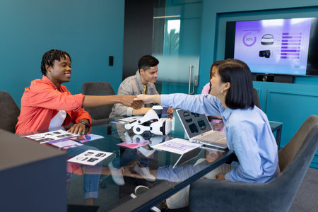 Business team discuss VR, startup, teamwork, and collaboration while shaking hands. They are in modern conference room with VR headsets and presentation on screen, unalteredの写真素材