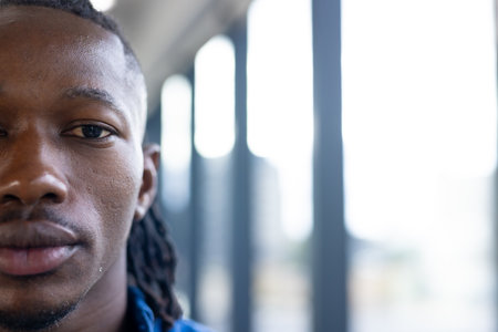 Man with dreadlocks looking at camera in modern office environment, copy space. Business, professional, corporate, workplace, unalteredの写真素材