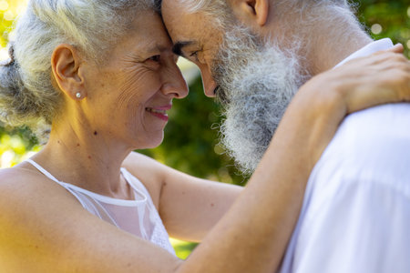 Embracing and smiling, senior bride and groom at wedding outdoors in park. love, affection, happiness, embrace, smile, tendernessの写真素材