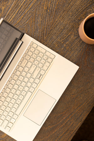 Laptop on wooden desk with coffee cup, working from home setup. Remote working, home office, productivity, workspace, technology, modernの写真素材