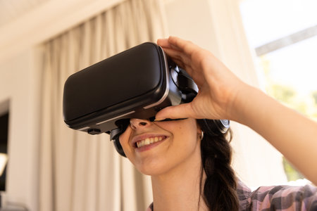 Using VR headset, woman smiling and enjoying virtual reality experience at home. Technology, gaming,...