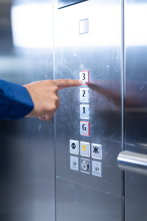 Pressing elevator button, person selecting third floor in modern office building. technology, lift, workplace, transportation, convenience, businessの写真素材