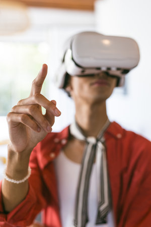 Using VR headset, young man interacting with virtual environment at home. Virtual reality,...