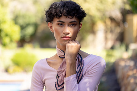 Posing confidently, transgender transgender woman standing outdoors with hand on chin. Confidence, empowerment, self-assurance, contemplation, pose, LGBTQの写真素材