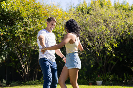 Dancing together, young couple enjoying time outdoors in garden. relationship, love, romantic,...