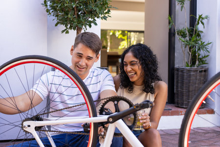 Fixing bicycle together, young couple enjoying outdoor activity and bonding. Cycling, teamwork,...