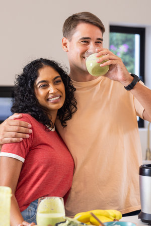 Drinking smoothies together, smiling couple in modern kitchen. Healthy, lifestyle, nutrition, fruit,...