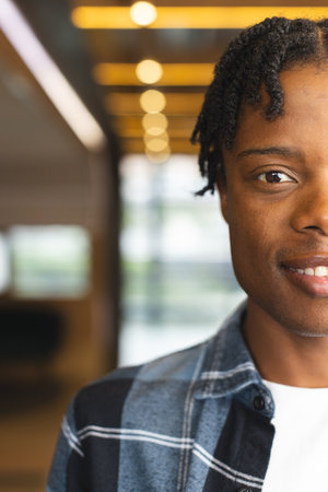 African American man standing indoors in a modern business office, looking at camera with copy...