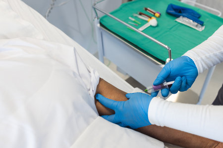 Nurse draws blood from a patient in a medical setting. Sterile equipment and professional care...