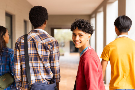 Walking in high school hallway, teenagers smiling and carrying backpacks. Teens, friendship, high high school, education, students, happinessの写真素材