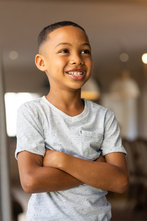 Smiling boy standing confidently at home with arms crossed. Confidence, child, happiness, indoor,...