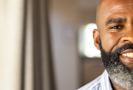 "Smiling african american senior man with beard in home, copy space. relaxation, indoors, lifestyle, positivityの写真素材