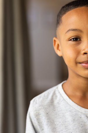 Smiling boy in casual shirt looking at camera, close-up portrait at home, copy space. Childhood,...