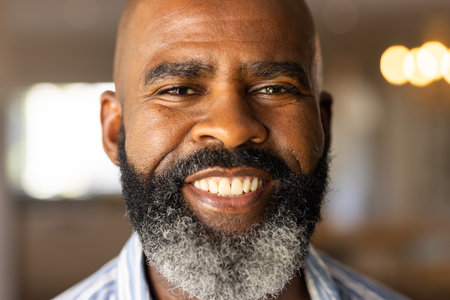 Smiling African American senior man with beard looking at camera, feeling happy and confident....