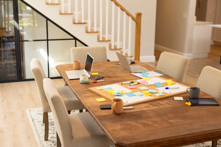 Brainstorming ideas, laptops and sticky notes on table in modern home office. Collaboration,...
