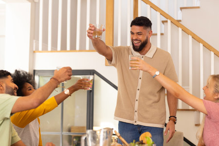 Toasting with drinks, diverse friends celebrating together in cheerful gathering. Celebration, party, socializingの写真素材