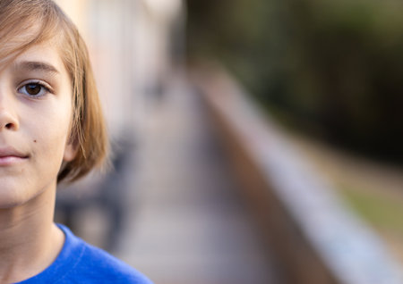 In school, boy standing outside, looking at camera with serious expression, copy space. Education,...