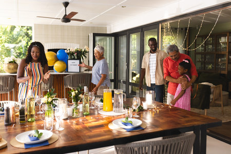 Multiracial family celebrating together , enjoying festive meal and joyful moments, in garden. Celebration, togetherness, holiday, dinner, happiness, gathering