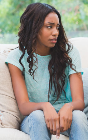 Upset woman being ignored by partner at home in the living roomの写真素材