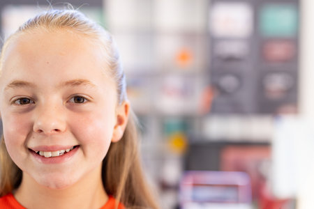 Smiling girl in school classroom, enjoying learning and feeling confident, copy space. Education,...