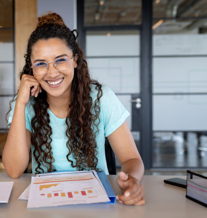 Reviewing business reports, smiling woman at modern office desk. professional, workplace, analysis,...